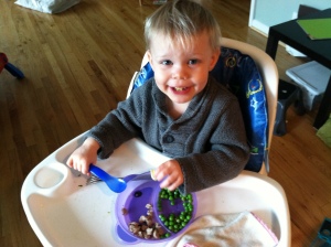 Eliah- trying to be enthused by her breakfast- peas, turkey, squash pancakes